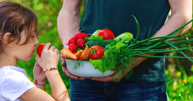 Un papa et sa fille avec les légumes du jardin