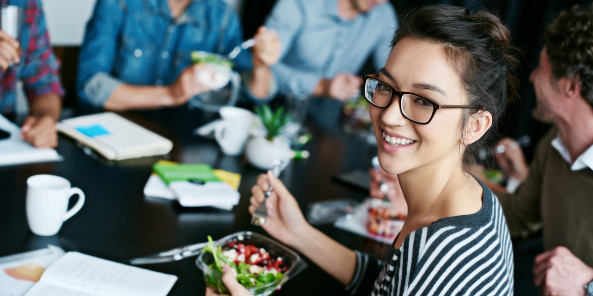 jeune fille déjeunant avec ses collègues au cours d'une réunion