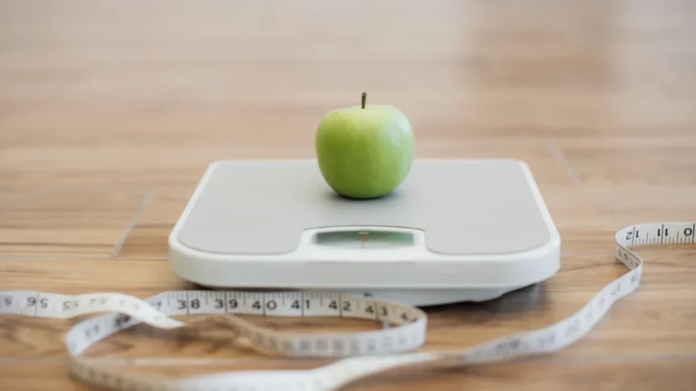 Balance et pomme illustrant pourquoi la restriction calorique ne suffit pas pour perdre du poids