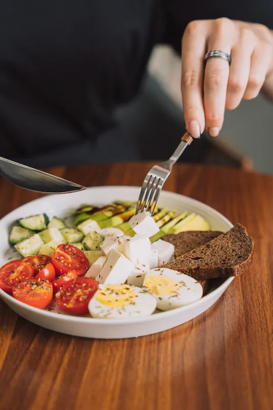 Assiette équilibrée avec légumes, œufs durs, fromage frais et pain complet - exemple de repas structuré selon les principes du livre 24h