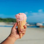 Main entre tenir cornet de la glace à la plage