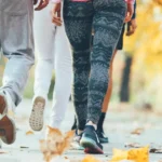 Groupe de personnes en marche rapide dans un parc en automne, activité physique recommandée pour la prévention du cancer du sein